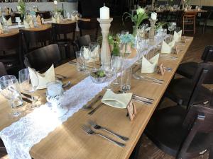 - une longue table en bois avec des verres et de l'argenterie dans l'établissement Schlaffass - Schlafen im Holzfass, à Tattendorf