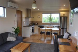 uma cozinha e sala de estar com um sofá e uma mesa em Aviator em New Plymouth