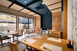 a dining room with wooden tables and chairs at Hotel Rose Garden Shinjuku in Tokyo
