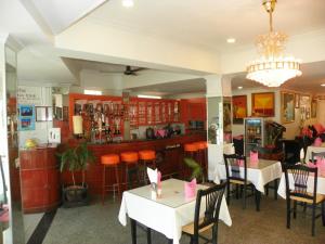 un restaurante con mesas y sillas y un bar en Orchid Hotel and Spa Kalim Bay, en Patong Beach
