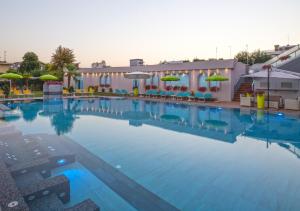 une grande piscine avec des chaises et des parasols dans l'établissement Hotel Terme Cristoforo, à Abano Terme