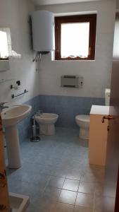 フォッポロにあるLe Terrazzeのバスルーム(洗面台2台、トイレ付)、窓が備わります。