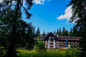 a building in the middle of a forest with trees at Апартаменти Малина in Pamporovo