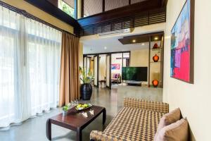 a living room with a couch and a table at New Star Beach Resort in Chaweng Noi Beach