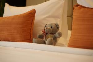 a stuffed teddy bear sitting on a bed at Hotel Oazis in Butuan