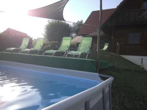 a row of chairs sitting next to a swimming pool at Blockhaus Familie Raidl in Riegersburg