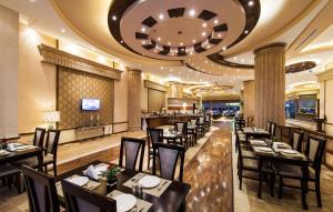 a dining room with tables and chairs in a restaurant at Boudl Buraydah in Buraydah