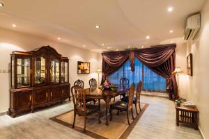 a dining room with a table and chairs and a large window at Boudl Al Nakheel in Unayzah