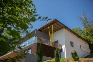 - un bâtiment blanc avec un balcon et une clôture dans l'établissement Villa Glamour, à Hadžići