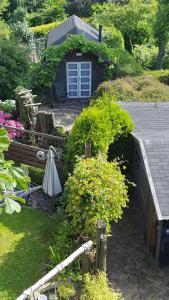 een tuin met een huis met een veranda en een aantal struiken bij Peter&Trienke's Bed&Brochje in Stiens