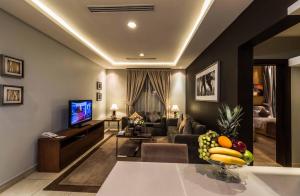 a living room with a couch and a television at Boudl Al Fakhria in Unayzah