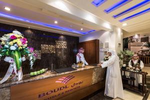 a couple of men standing at a counter in a salon at Boudl Al Fakhria in Unayzah +22 photos
