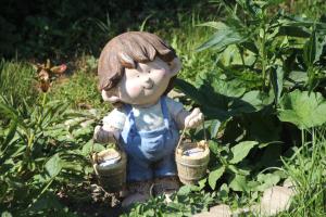 a small statue of a little boy holding two baskets at Radler's Hof in Letschin