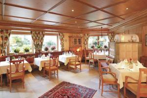 Hotel Pension Sonnleiten في تكس: غرفة طعام مع طاولات وكراسي بيضاء