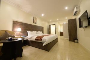 ein Hotelzimmer mit einem Bett und einem TV in der Unterkunft Top View - شقق المنظر in Al Hofuf
