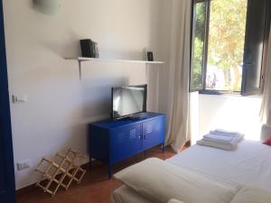 トラーパニにあるCasa La Marina 62, centrale, sul porto di Trapaniのベッド2台、青いキャビネットの上にテレビが備わる客室です。