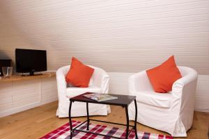sala de estar con 2 sillas, mesa y TV en Landhaus Lillesand, en Esens