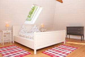 a bedroom with a white bed and a window at Landhaus Lillesand in Esens