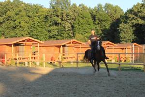 a man riding a horse in front of a cabin at Complex HAMAK in Iaşi
