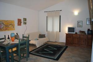 una sala de estar con una mesa y un sofá en Casa Su Catreathu, en Orosei