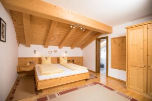 ein Schlafzimmer mit einem Bett in einem Zimmer mit Holzdecken in der Unterkunft Pension Winklerkreuz in Alpbach