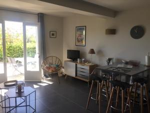 a living room with a table and chairs and a television at Villa Heliomar in Cavalaire-sur-Mer
