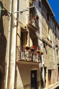 ein Gebäude mit zwei Balkonen mit Blumen darauf in der Unterkunft Well equipped village house close to historic centre - Pézenas in Pézenas