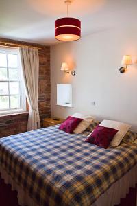 a bedroom with a bed with a checkered blanket at Ecclefechan Hotel in Ecclefechan