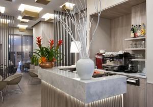 a lobby with a counter with a vase on it at Hotel Gamma in Milan