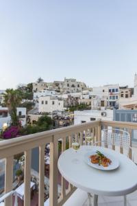un tavolo bianco con un piatto di cibo sul balcone di Castle Mansions a Naxos Chora