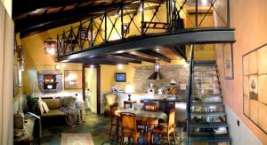 a spiral staircase in a living room with a table and chairs at Dimora I Manichei in Monforte dʼAlba