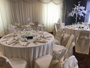 a room filled with tables with white chairs and tablesearcher at The Portland in Ashington