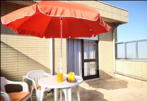 een tafel met een rode parasol op een patio bij Hotel Palanca in Porto