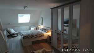 - une chambre avec un lit et une porte coulissante en verre dans l'établissement Ferienwohnung An der Jordanshöhe, à Sankt-Andreasberg