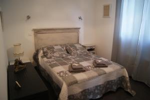 a bedroom with a bed with two towels on it at Appart'Hôtel Les Rochers in Auriol