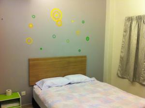 een slaapkamer met een bed met groene stickers op de muur bij Malacca Homestay Apartment 2 in Melaka