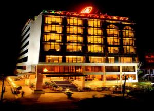 un grand bâtiment avec des lumières allumées la nuit dans l'établissement Classic Sarovar Portico Trivandrum, à Trivandrum