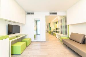 um corredor de um escritório com um sofá e uma televisão em Hotel Tenda Rossa em Marina di Carrara