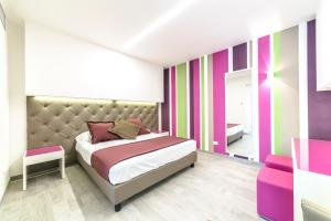 1 dormitorio con 1 cama y una pared colorida en Hotel Tenda Rossa, en Marina di Carrara