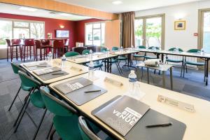 a row of tables and chairs in a room with windows at Campanile Toulouse Sesquieres in Toulouse