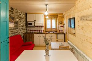 cocina y sala de estar con sofá rojo en Casa Muro Ordesa, en Frajén