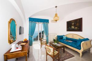 a living room with a blue couch and a table at Hotel Villa Gabrisa in Positano
