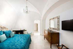 a bedroom with a bed and a tv and a mirror at Hotel Villa Gabrisa in Positano