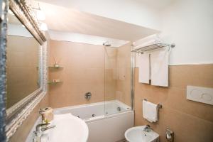 a bathroom with a sink and a tub and a toilet at Hotel Villa Gabrisa in Positano
