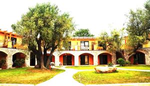 a large house with a tree in the yard at Park Hotel Cilento in Marina di Camerota