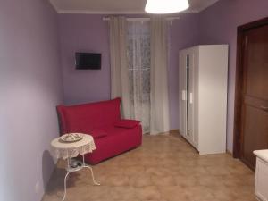 La rosa sul lago في ترفيجنانو رومانو: غرفة معيشة مع أريكة حمراء وطاولة