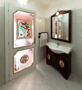 La salle de bains est pourvue d'un lavabo et d'un miroir. dans l'établissement B&B Myosotis, à Introdacqua