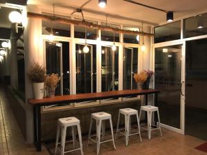 eine Bar mit Hockern vor einem Fenster in der Unterkunft De Nan Hotel in Nan
