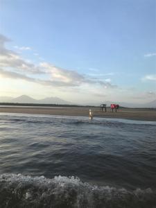 uma pessoa de pé na praia perto da água em Puerto Barillas em Bahia de Jiquilisco