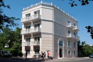 a group of people walking in front of a white building at Geneva Resort Hotel in Odesa